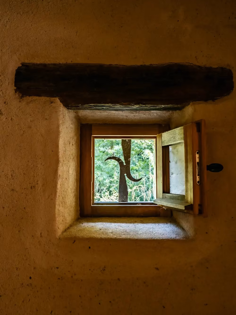 Piccola finestra in legno in un muro di pietra spesso