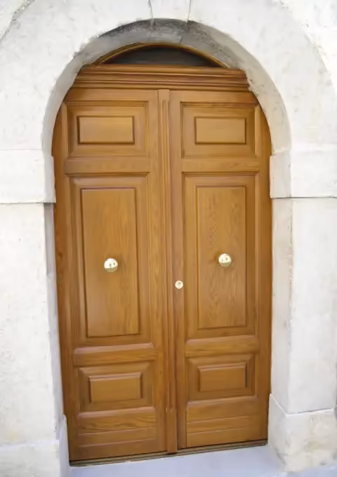 Portone in rovere massiccio in un vano ad arco in pietra