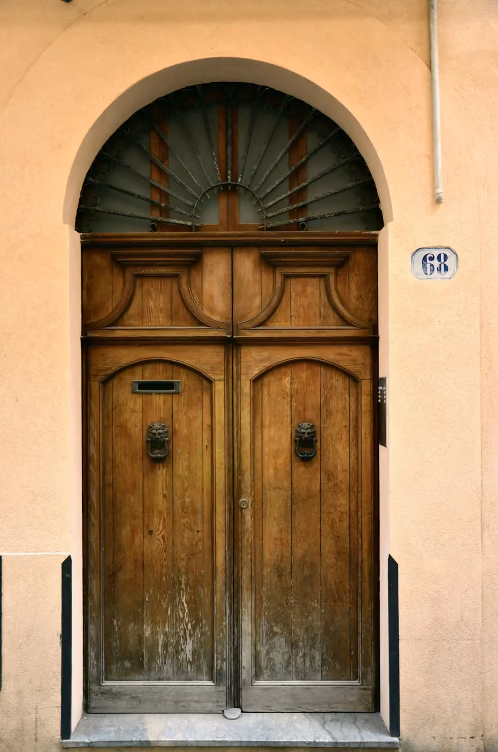 Portone in legno a due ante con sopraluce ad arco